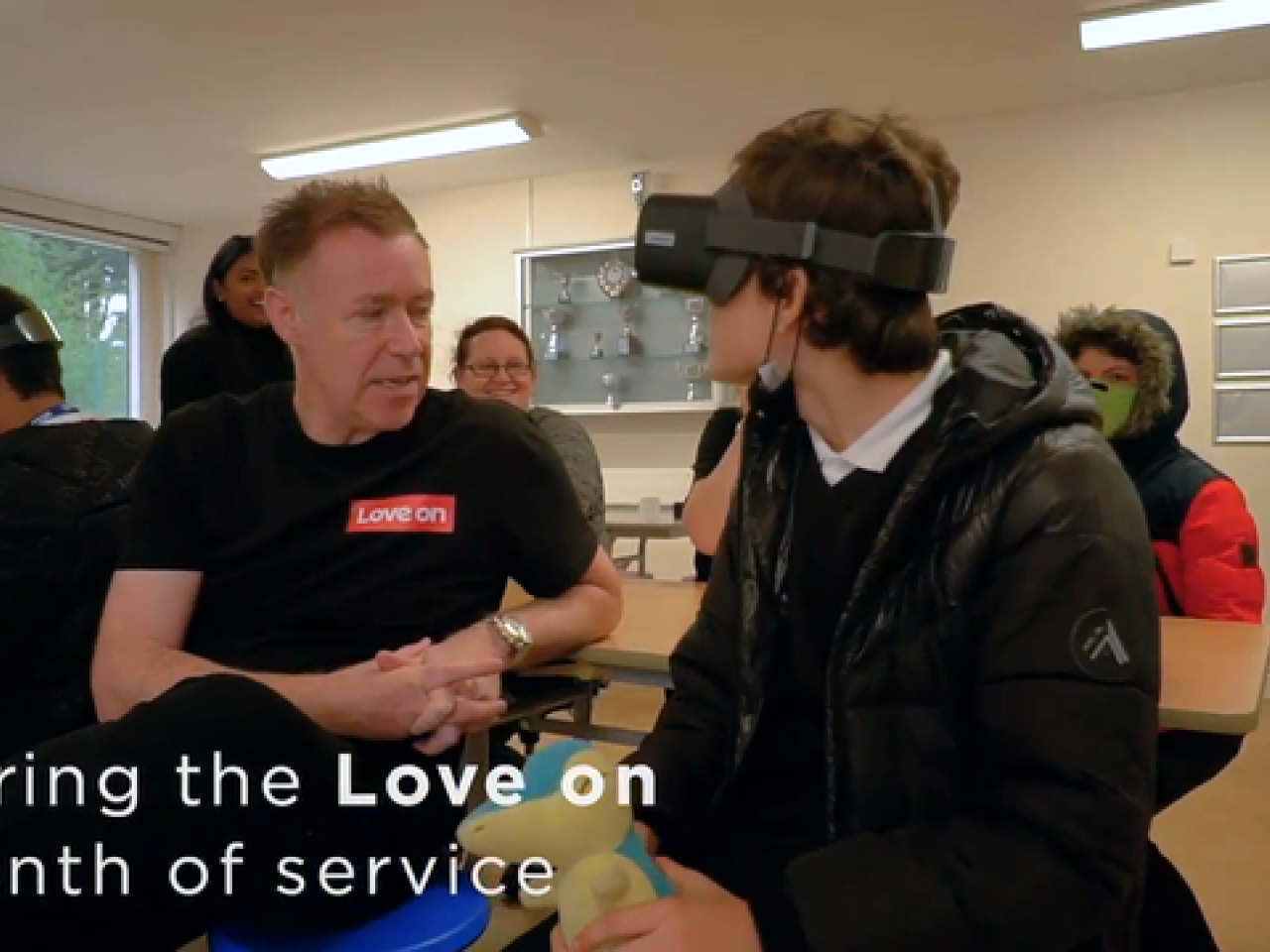 戴着VR头盔的人面对着一个穿着联想t恤的人