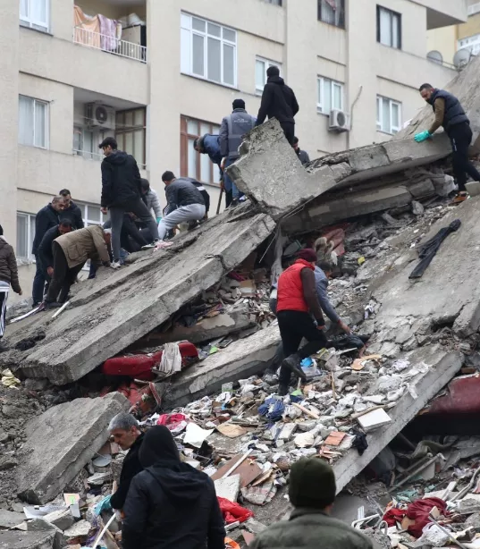 人民爬上地震造成的瓦砾