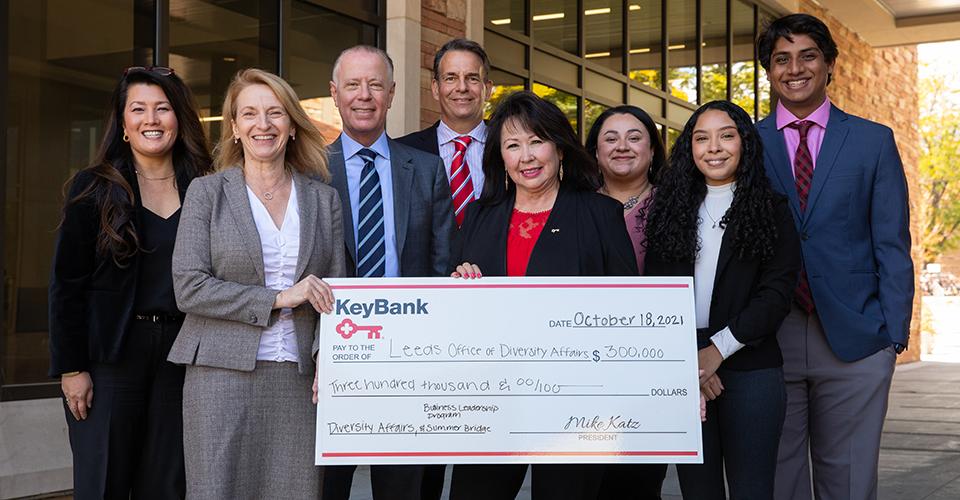 利兹商学院和KeyBank集团持有300 000美元的支票5名女性和3名男性居中