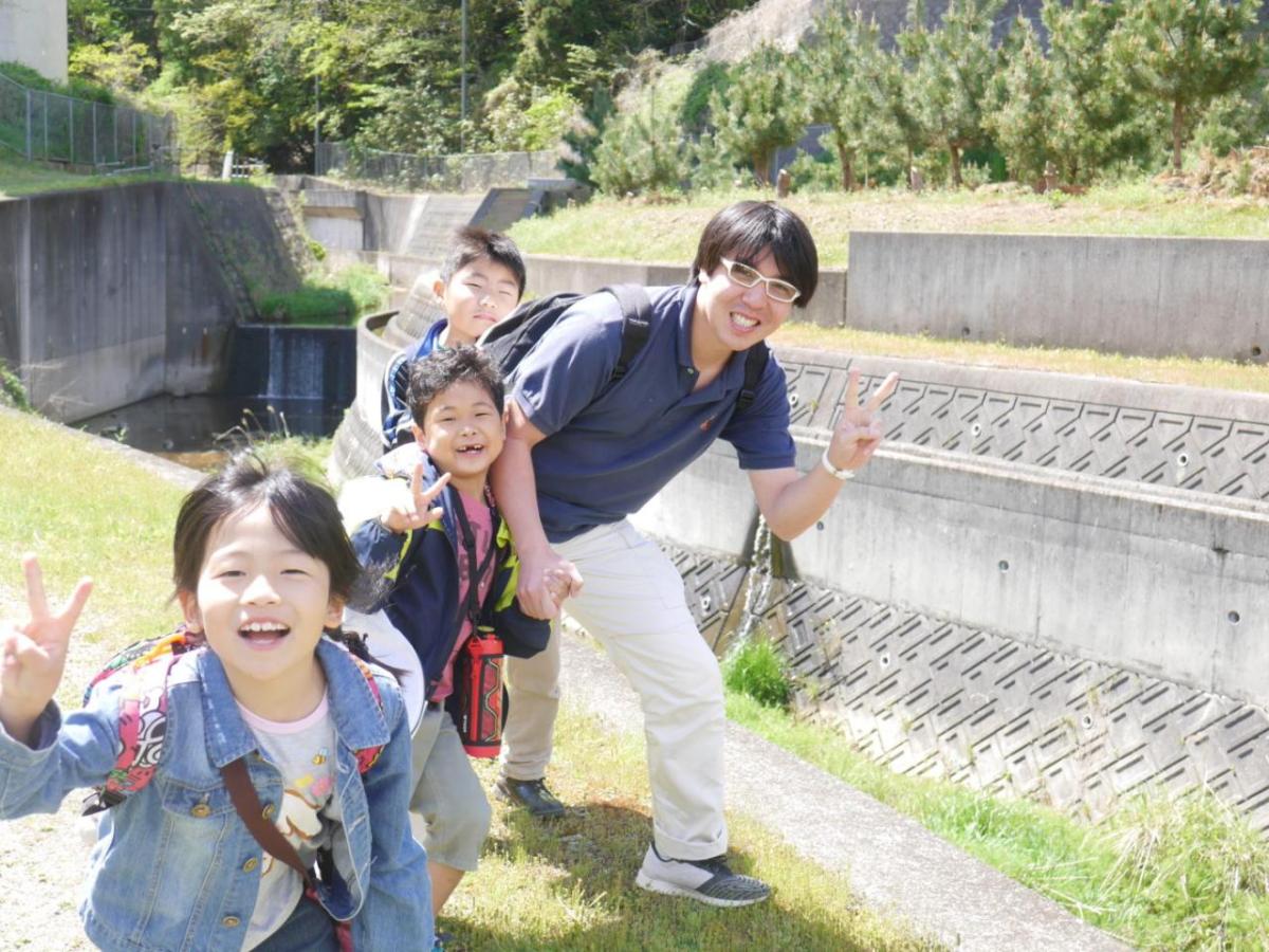 神户JitsugyoGakuin儿童与成人在实地考察中笑